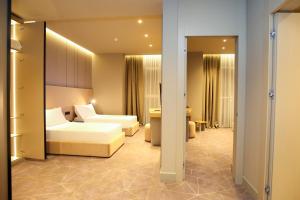 ヴロラにあるThe Central View Boutique Hotelのベッドとリビングルームが備わるホテルルームです。