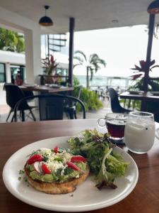 a plate with a sandwich and a salad on a table at Hotel Aldea 19 Bacalar in Bacalar