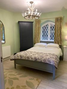 a bedroom with a large bed with a chandelier at The Stables Apartment at Cefn Tilla Court, Usk in Usk
