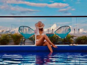 a woman in a bikini sitting in a swimming pool at Meliora by Bunik in Playa del Carmen