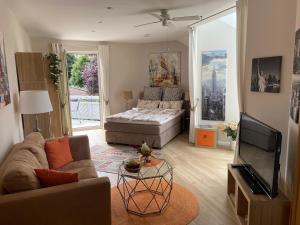 a living room with a couch and a television at Villa "Auszeit" in Hohen Neuendorf