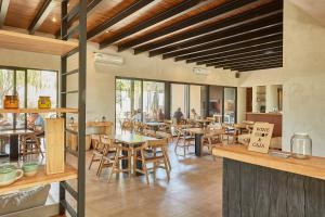a restaurant with wooden tables and chairs and windows at Casa de Huéspedes Bodega Gimenez Riili in Los Sauces