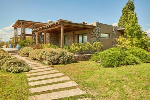 a house with a stone pathway leading to a yard at Casa de Huéspedes Bodega Gimenez Riili in Los Sauces