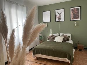 Dormitorio verde con cama con ciervo en la pared en Chez Tatie Ménie, en Fraissé-des-Corbières