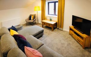 ein Wohnzimmer mit Couch und Flachbildfernseher in der Unterkunft Kettlesing Cottage, Harrogate in Harrogate
