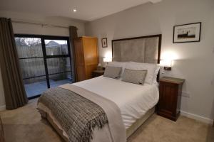sypialnia z dużym białym łóżkiem i oknem w obiekcie The Burrow at Tankerton w mieście Whitstable