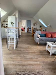 a living room with a couch and a table at Appartement cosy sous les toits in Lion-sur-Mer