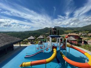 a pool with a water slide at a resort at Escarpas resort in Capitólio