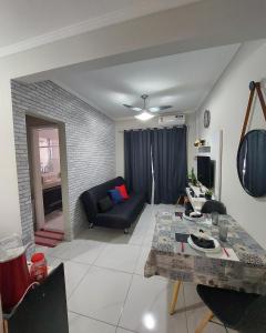 a living room with a table and a couch at Apartamento Edifício Turim Ponta da Praia Santos in Santos