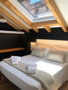 sypialnia z dużym białym łóżkiem i świetlikiem w obiekcie Ottomood House Catania w Katanii