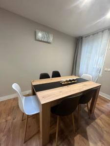 ein Esszimmer mit einem Holztisch und Stühlen in der Unterkunft Appartement cosy parking idéal JO 2024 in Le Bourget