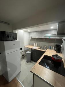 eine Küche mit einem weißen Kühlschrank und einer Theke in der Unterkunft Appartement cosy parking idéal JO 2024 in Le Bourget