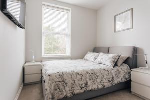 um quarto branco com uma cama e uma janela em Holiday home near train station em Bournemouth