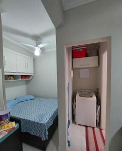a small room with a bed and a small refrigerator at Apartamento Edifício Turim Ponta da Praia Santos in Santos