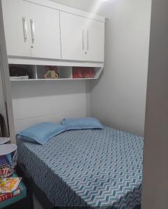a small bedroom with a bed and white cabinets at Apartamento Edifício Turim Ponta da Praia Santos in Santos