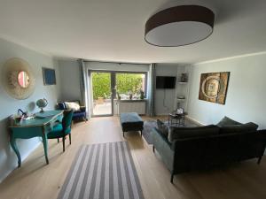 un soggiorno con un divano e un tavolo di Schöne Wohnung mit Ausblick und Gartensitzplatz a Lörrach
