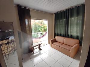 ein Wohnzimmer mit einer Couch und einem Fenster in der Unterkunft Sibauma Aparts in Pipa