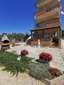 ein Haus mit Blumen davor in der Unterkunft Apartment Alena 1 i 2 in Bibinje