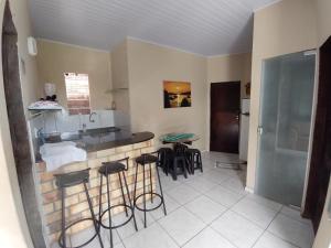 eine Küche mit einer Spüle sowie einem Tisch und Stühlen in der Unterkunft Sibauma Aparts in Pipa