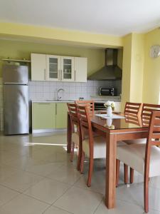 eine Küche mit einem Tisch und Stühlen sowie einem Kühlschrank in der Unterkunft Apartment Alena 1 i 2 in Bibinje