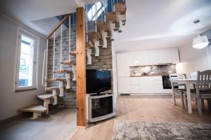 a living room with a tv and stairs in a room at Cabin Guesthouse with free parking in Pärnu