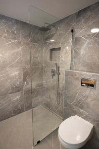 a bathroom with a toilet and a glass shower at Cabin Guesthouse in P&auml;rnu