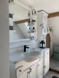 a bathroom with a white sink and a mirror at Romantische Wohnung Bauernhof, 100m2 offenes Dachgeschoss in Auhausen