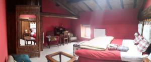 a bedroom with a red wall with a bed in it at les natur'elles in La Chapelle-en-Lafaye