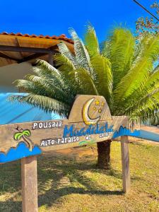 a wooden sign in front of a palm tree at Pousada Mirante da Lua in Alto Paraíso de Goiás