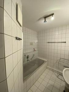 Baño blanco con bañera y lavamanos en Alpen luaga, en Sonthofen