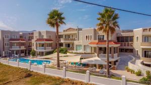 een rij appartementen met een zwembad en palmbomen bij Stavroula Hotel Palace in Kissamos