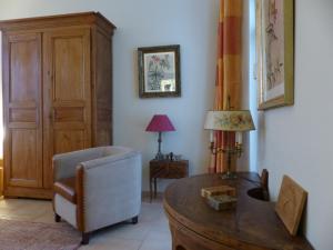 a living room with a chair and a table at LE JARDIN DU ROSSIGNOL in Willeman