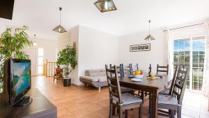 sala de estar con mesa de comedor y TV en Villa Brisa - Lloret de Mar, en Mont Barbat