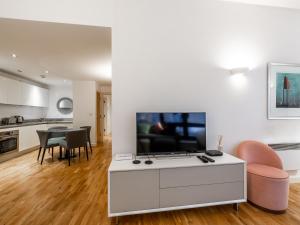 a living room with a tv and a table with chairs at Pass the Keys - Modern Studio Apartment in the heart of Shoreditch in London