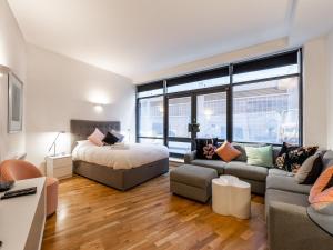 a living room with a bed and a couch at Pass the Keys - Modern Studio Apartment in the heart of Shoreditch in London