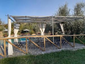 a patio with an umbrella and chairs under a pool at Camere con vista in Valdichiana in Marciano Della Chiana