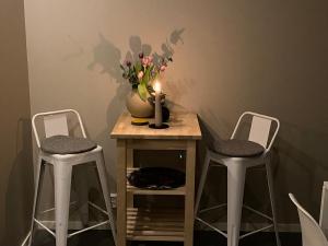 einen Tisch mit einer Vase mit einer Kerze und 2 Stühlen in der Unterkunft Attefallshus på Ängö i Kalmar in Kalmar