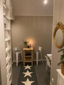 Zimmer mit einem Tisch, Stühlen und einem Spiegel in der Unterkunft Attefallshus på Ängö i Kalmar in Kalmar