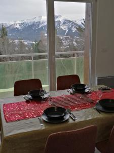 豐羅默奧代洛維亞的住宿－superbe apart vue panoramique sur les pyrénées,balcon plein sud，享有白雪山景的桌子