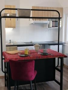 a kitchen with a table with two chairs and a loft bed at superbe apart vue panoramique sur les pyrénées,balcon plein sud in Font-Romeu-Odeillo-Via
