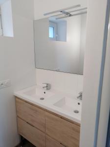 a white bathroom with a sink and a mirror at superbe apart vue panoramique sur les pyrénées,balcon plein sud in Font-Romeu-Odeillo-Via