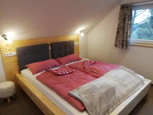 ein Schlafzimmer mit einem Bett mit roten Decken und einem Fenster in der Unterkunft Fewo bei Reuters - Haus Tellkoppe in Waldidylle