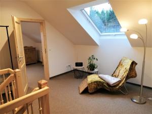 Zimmer im Dachgeschoss mit einem Stuhl und einem Dachfenster in der Unterkunft Fewo bei Reuters - Haus Tellkoppe in Waldidylle