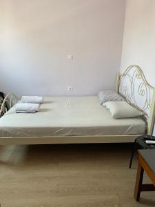 Bett in einem Zimmer mit weißen Wänden in der Unterkunft Private Rooms with a Beautiful Veranda in Iraklio