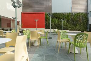 a restaurant with tables and chairs and a red wall at Regency Way Montevideo Hotel in Montevideo