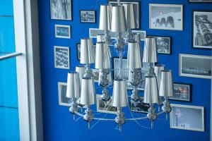 a chandelier hanging from a blue wall with pictures at Regency Way Montevideo Hotel in Montevideo