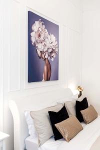 a picture of a flower above a white couch with pillows at Appartamento Corfù in Lido di Ostia