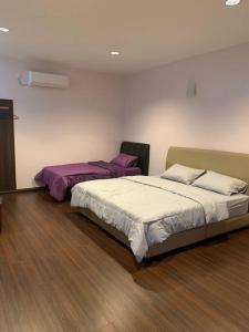 two beds in a room with wood floors at 4-6人家庭 Cozy Home @ Kutoba Square in Tawau