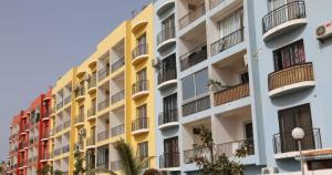 um edifício de apartamentos amarelo e branco com varandas em JOLI APPARTEMENT A DAKAR,ESPACES MAMELLE em Dakar
