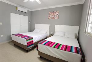 2 nebeneinander sitzende Betten in einem Schlafzimmer in der Unterkunft Casa Buba in Cozumel